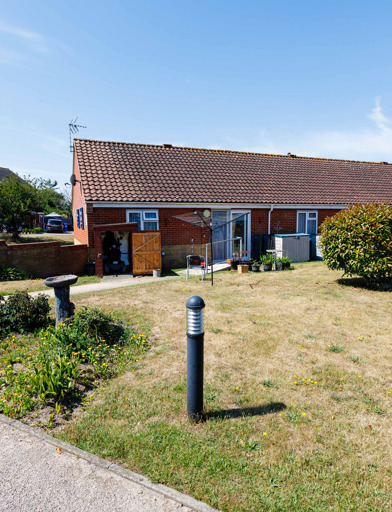 Attractive communal garden with flowerbeds, solar-powered lighting, hedges and decorative water features 