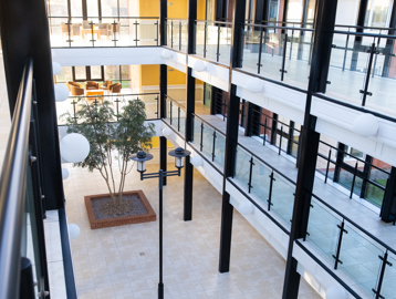 A view from the top floor of one of the large open hallways looking down to the ground floor