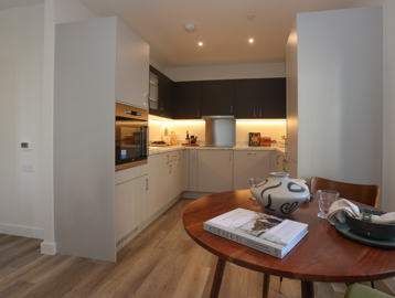 A photo of the open plan kitchen and dining room inside a show apartment at Minterne Apartments