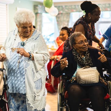 Two residents dancing, one stood and one in a wheelchair