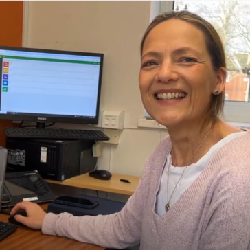 A woman smiling at a computer