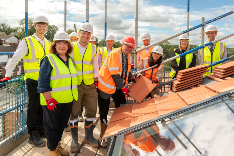 A group of colleagues and partners of Housing 21 on the roof of a new extra care scheme