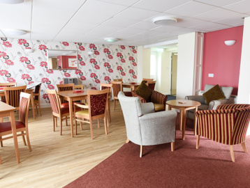 Communal lounge and dining area with soft seating and dining tables and chairs
