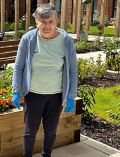 Resident Janet standing in the communal garden 