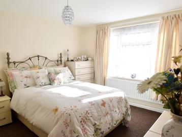 Double bedroom with furniture and flowers around the room