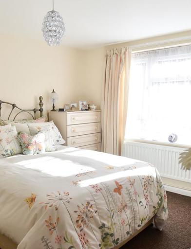 Double bedroom with furniture and flowers around the room 