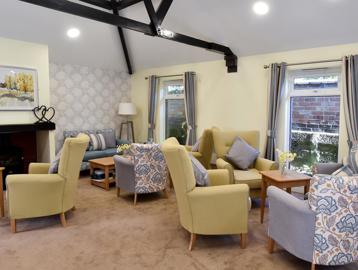 Residents' lounge with soft seating around a fireplace