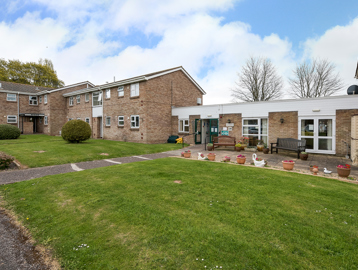 Front garden to the entrance of the scheme with plants and ornaments