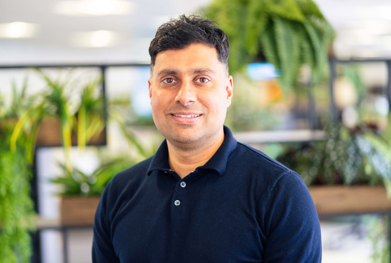 Man in dark blue top smiling