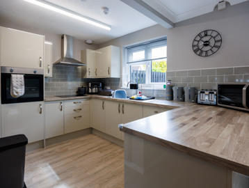 A bright kitchen area with an oven, hob and preparation areas