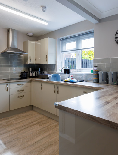 A bright kitchen area with an oven, hob and preparation areas 