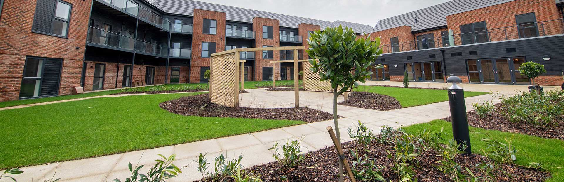 Large garden area with pathway and plants around a central patio area