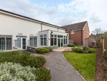 Communal garden with path, grassed area and shed at Alice Bye Court