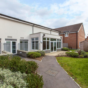 Communal garden with path, grassed area and shed at Alice Bye Court