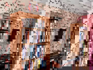 Communal area with library books, piano and TV at Alexandra Court