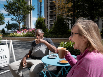Minterne Apartments' residents pictured having a coffee and chat outside their local cafe sitting outside