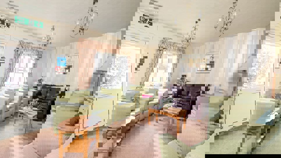 Residents' lounge with soft seating and tables