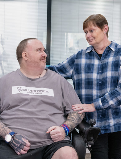 Chris, a Housing 21 resident, and his sister Wendy, smile at each other 