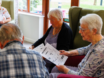 Residents playing a paper-based puzzle game together at Mere View
