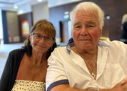 Residents who are a couple sitting down smiling 