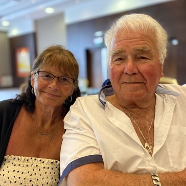 Residents who are a couple sitting down smiling 