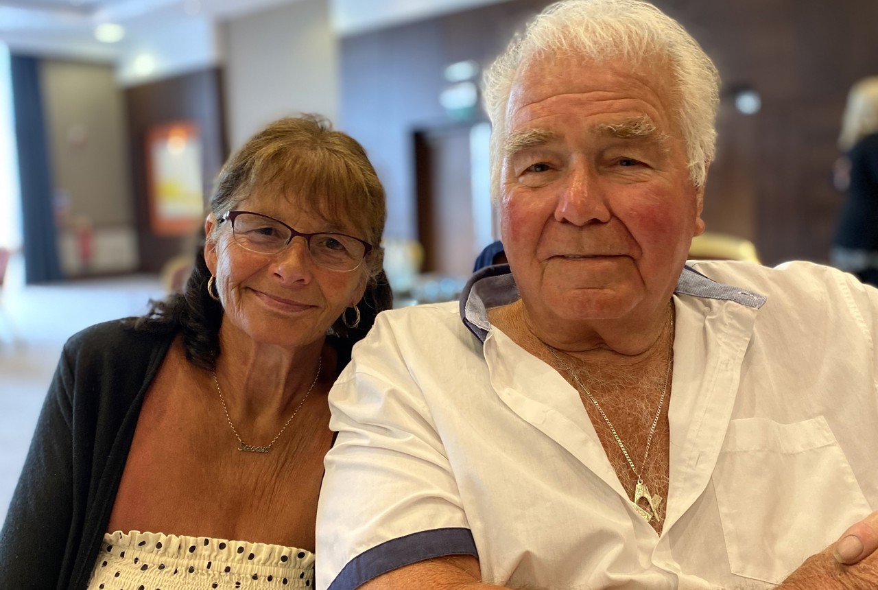 Residents who are a couple sitting down smiling 