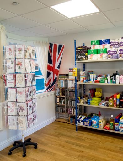 Inside of the communal shop with cards and household items on display 