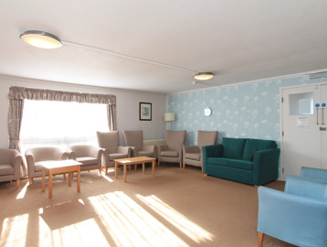 Residents' lounge with soft seating and coffee tables