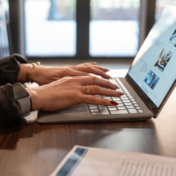 A close-up photo of a person typing on a laptop keyboard