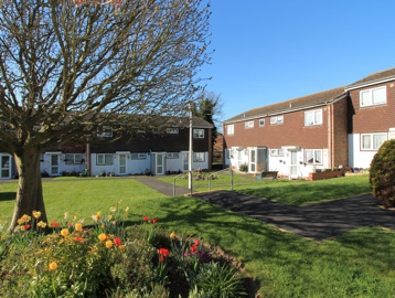 Large communal garden area to the front of the scheme with lawn, plants and trees