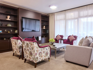 the scheme communal area with a tv and chairs