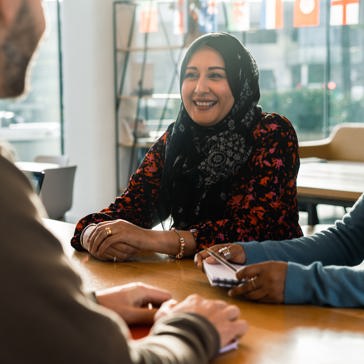 Corporate employees sitting at a table smiling