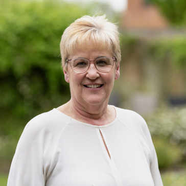 A woman in glasses smiling
