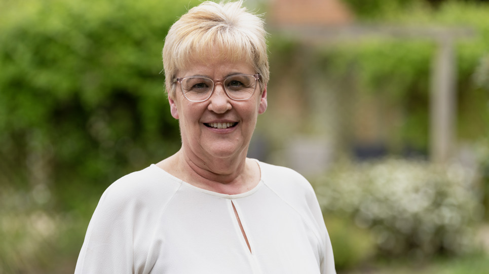 A woman in glasses smiling