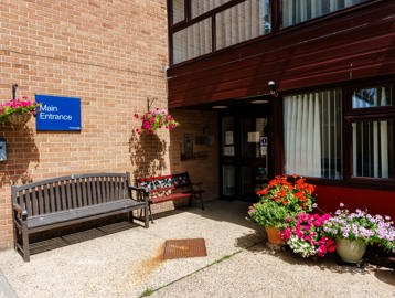Main entrance of Hildesley Court with a bench and flowerpots outside