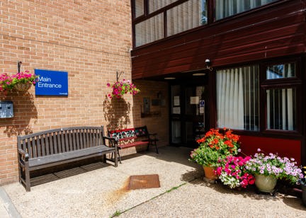 Main entrance of Hildesley Court with a bench and flowerpots outside