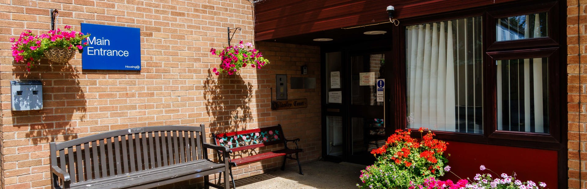 Main entrance of Hildesley Court with a bench and flowerpots outside