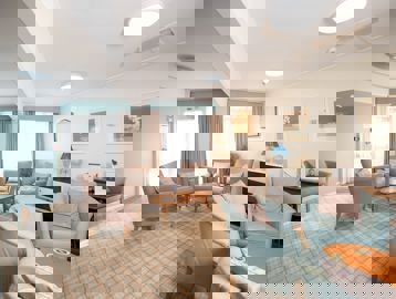 Residents' lounge with soft seating and coffee tables and check-patterned carpet
