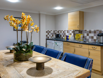 Inside the communal kitchen at Oakwood Gardens. Featuring a dining table, sink and fridge 