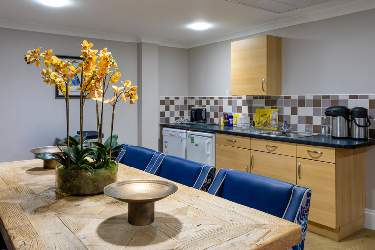 Inside the communal kitchen at Oakwood Gardens. Featuring a dining table, sink and fridge 