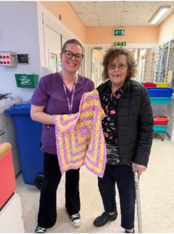 A person holding a blanket and smiling at the camera
AI-generated content may be incorrect.