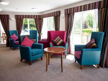 Residents' lounge with armchairs and tables