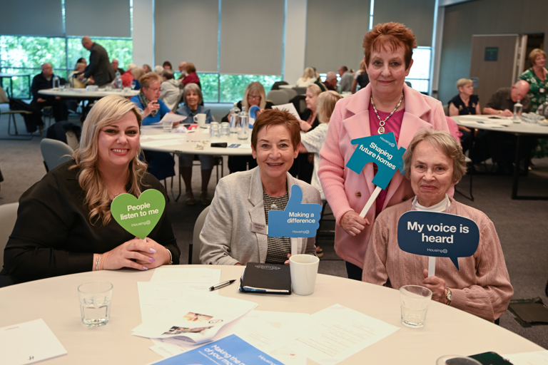 Residents sat at a round table with senior Housing 21 leaders, all smiling at the camera