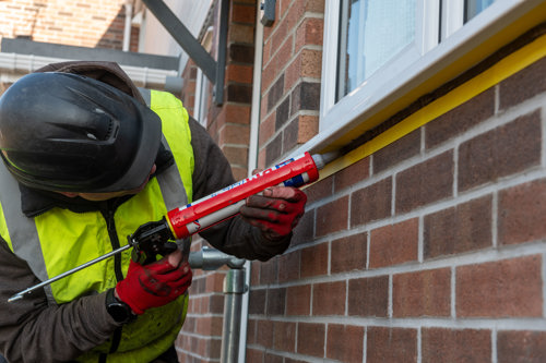 Silicone being applied to a window frame
