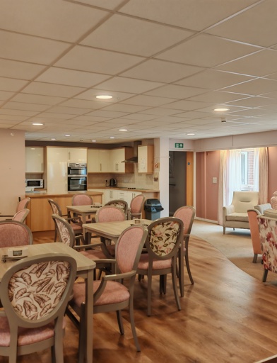 An open lounge, with dinning tables and chairs, sofa style seating, and a small kitchenette 