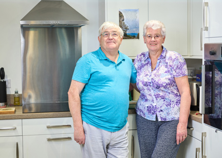 Extra Care stood in the kitchen in their apartment