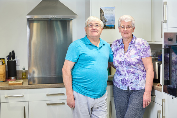 Extra Care stood in the kitchen in their apartment