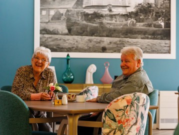 Two residents enjoying time together in the café area