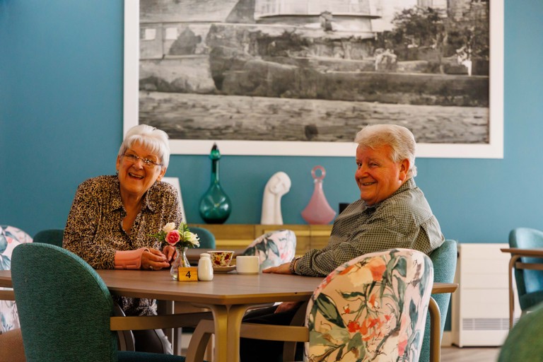 Two residents enjoying time together in the café area