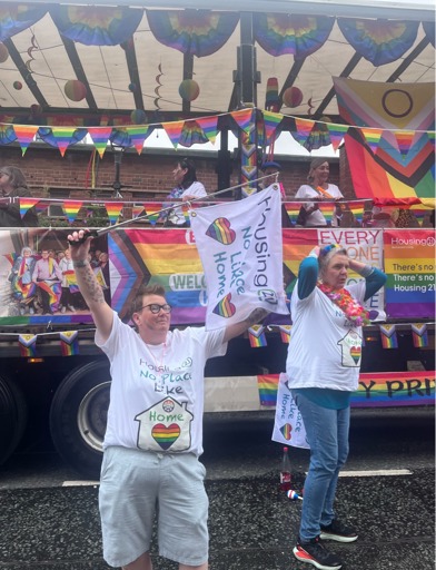 Rainbow decorated lorry with flags and woman celebrating 